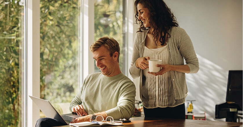 happy couple looking at laptop